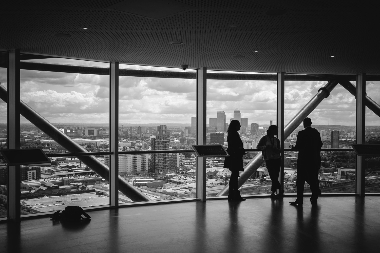 Colleagues in conversation at floor-to-ceiling windows overlooking a city skyline
